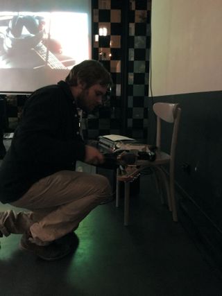 The Pleasure Is All Mine installation composed of an electric guitar, a magic wand vibrator, and a printed score at Nowa Orgia Myśli inauguration party in Warsaw.